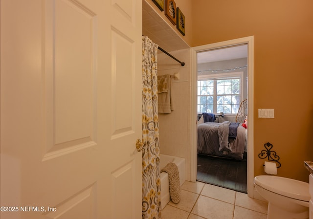 bathroom with toilet, shower / bath combo with shower curtain, and tile patterned floors