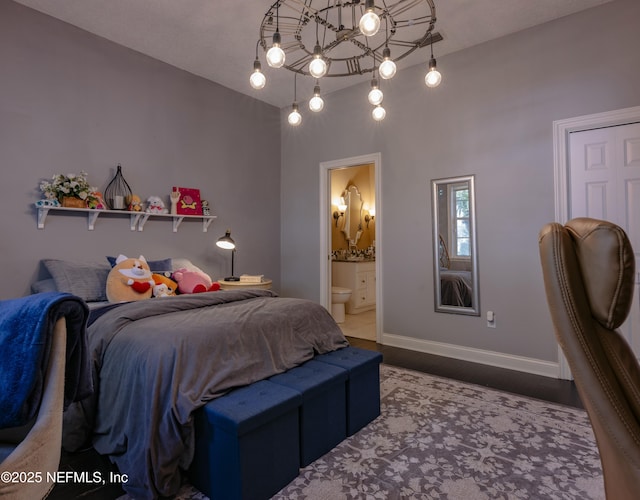 bedroom featuring connected bathroom, baseboards, and wood finished floors