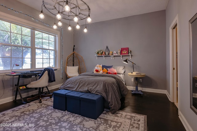 bedroom featuring baseboards and wood finished floors