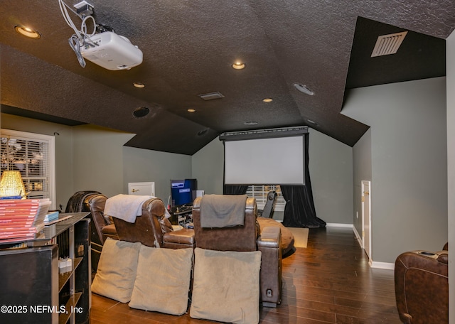 cinema room with lofted ceiling, a textured ceiling, baseboards, and wood finished floors