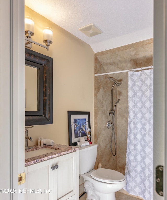 bathroom featuring visible vents, a shower with shower curtain, toilet, a textured ceiling, and vanity