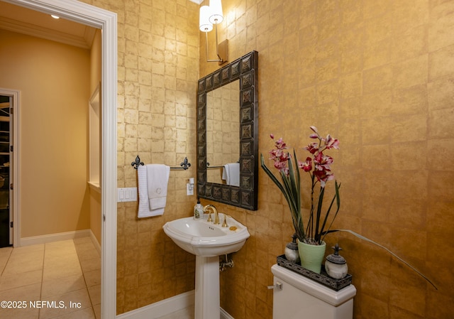 bathroom featuring baseboards, ornamental molding, tile walls, and tile patterned floors