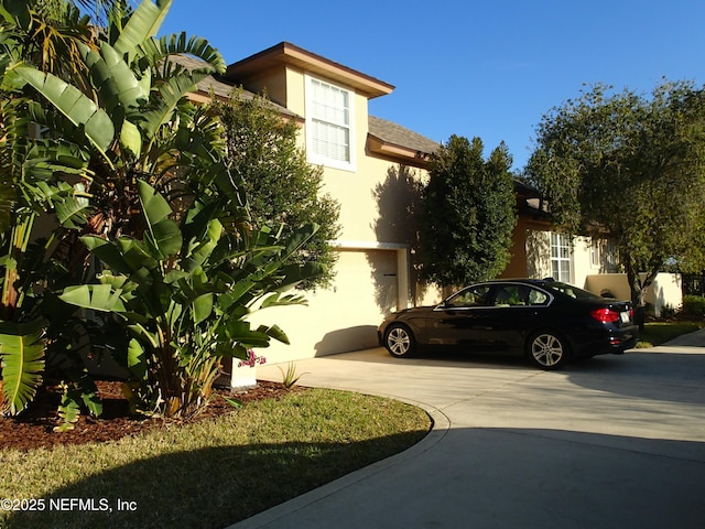 view of front of property with concrete driveway and stucco siding