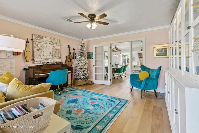 sitting room with ceiling fan, ornamental molding, a textured ceiling, and light hardwood / wood-style flooring