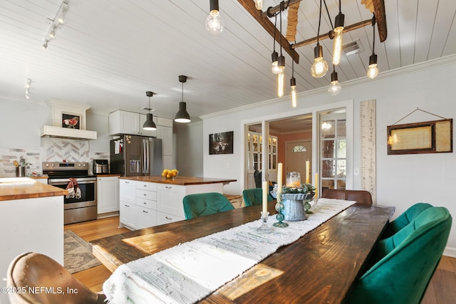 dining room with light hardwood / wood-style floors, wooden ceiling, rail lighting, and ornamental molding