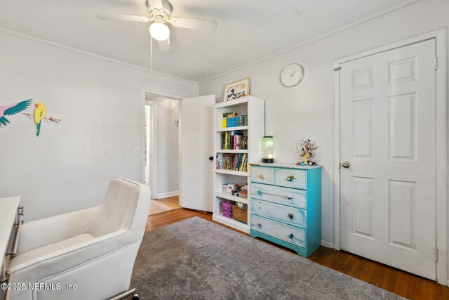 bedroom featuring dark hardwood / wood-style flooring, ornamental molding, and ceiling fan