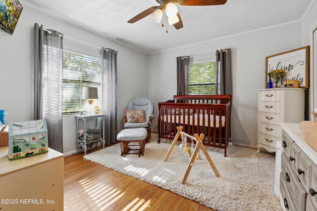 bedroom featuring a textured ceiling, crown molding, ceiling fan, and light hardwood / wood-style flooring