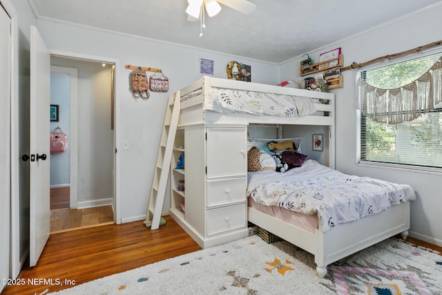 bedroom featuring ceiling fan, ornamental molding, and wood-type flooring