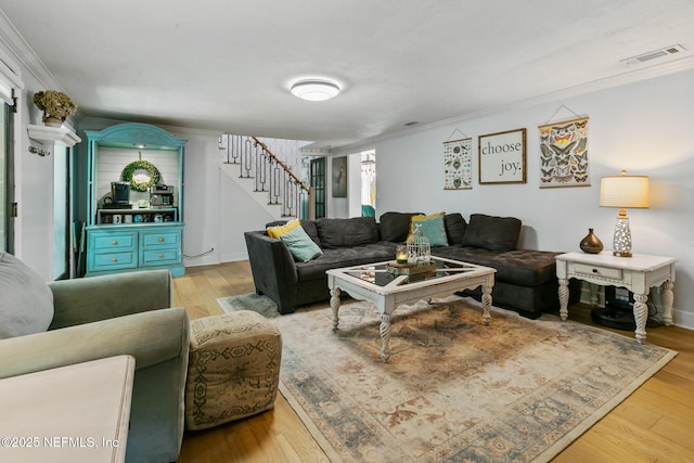 living room featuring light hardwood / wood-style flooring and crown molding