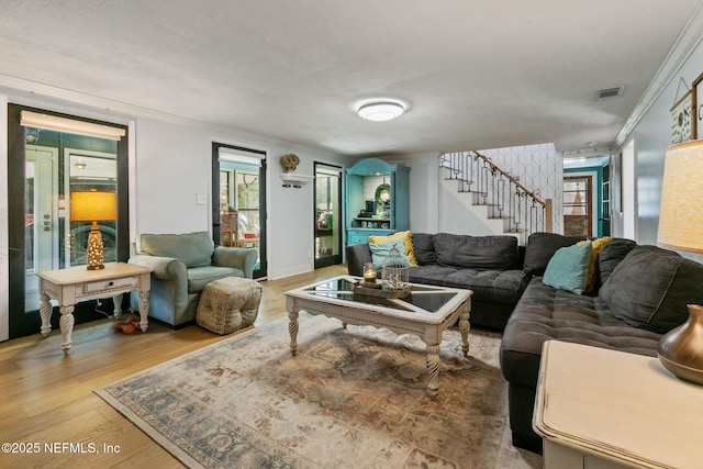 living room featuring light hardwood / wood-style floors and crown molding