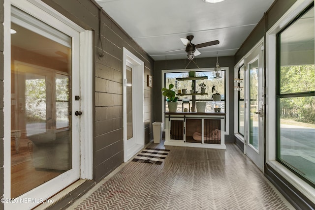 unfurnished sunroom with ceiling fan