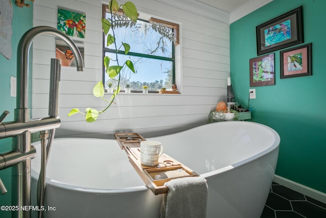 bathroom with ornamental molding, a bath, and tile patterned floors