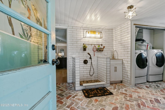 clothes washing area featuring sink, independent washer and dryer, and wood ceiling