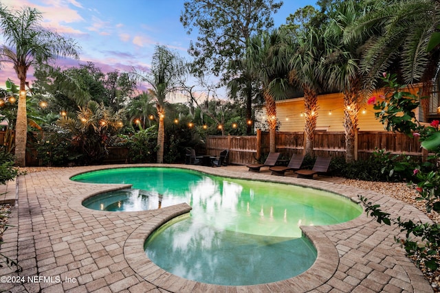 pool at dusk with a patio