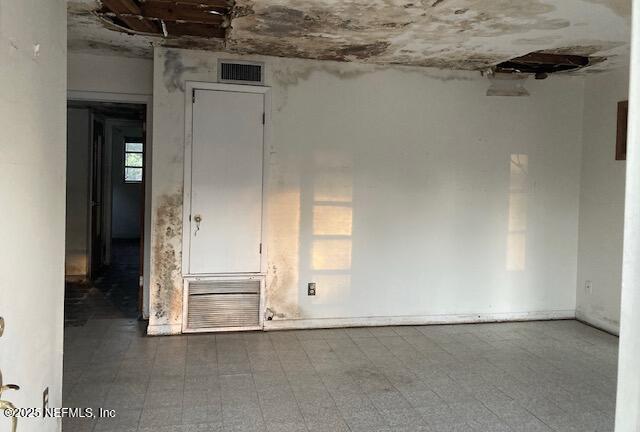 spare room with tile patterned floors and visible vents