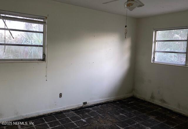 empty room featuring baseboards and a ceiling fan