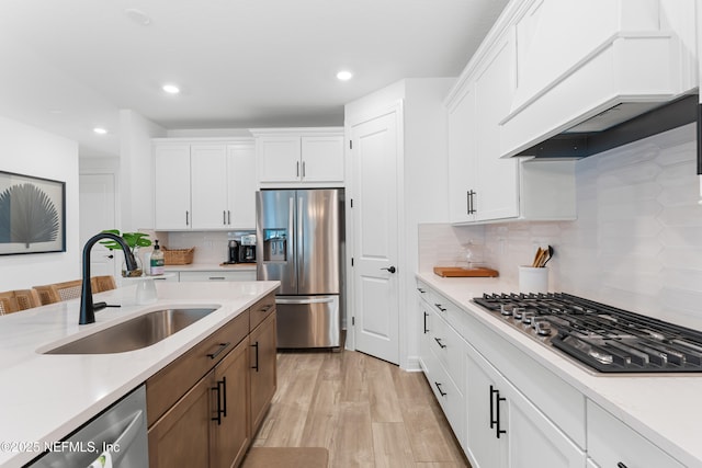 kitchen featuring premium range hood, appliances with stainless steel finishes, and white cabinetry