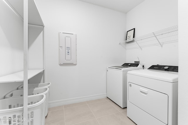 washroom featuring laundry area, electric panel, baseboards, independent washer and dryer, and light tile patterned flooring