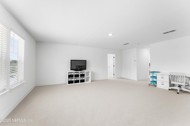 interior space with light carpet, visible vents, and baseboards