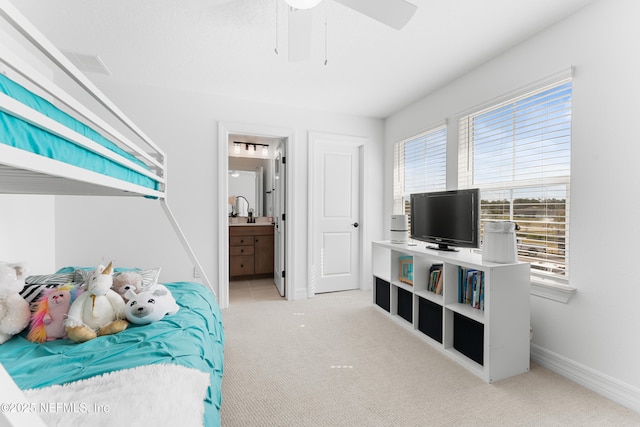 bedroom with baseboards, ceiling fan, connected bathroom, and light colored carpet