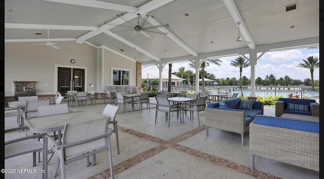 view of patio with a water view, an outdoor hangout area, outdoor dining space, ceiling fan, and fence