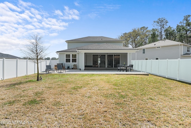 back of house with a lawn, a shingled roof, a fenced backyard, and a patio area