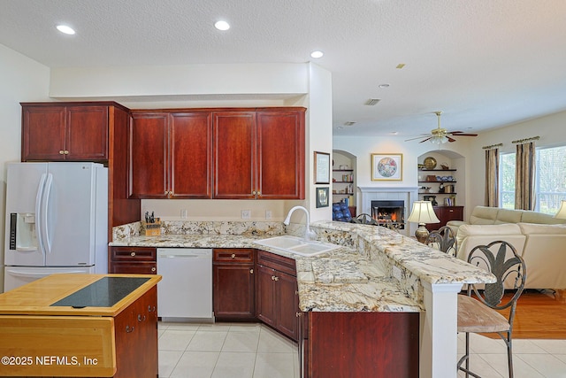 3383 Olympic Dr, Green Cove Springs, FL 32043 - kitchen with dark brown cabinets, open floor plan, a sink, and white appliances