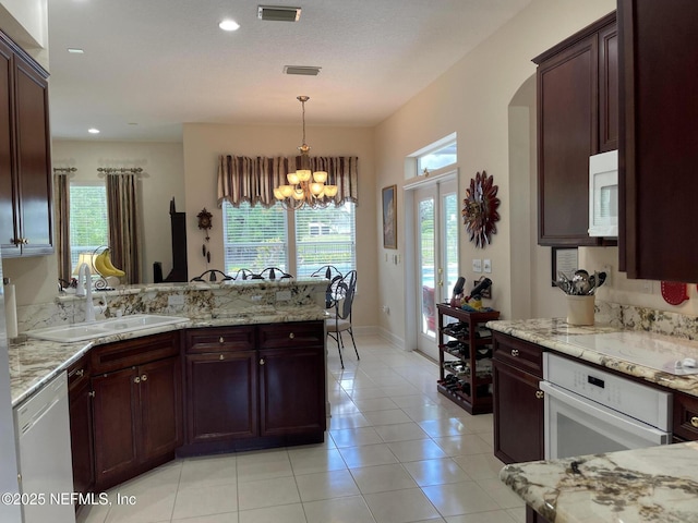 3383 Olympic Dr, Green Cove Springs, FL 32043 - kitchen featuring a peninsula, a sink, visible vents, white appliances, and a chandelier