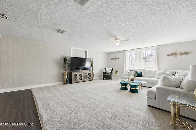 10605 Arnez Rd, Jacksonville, FL 32218 - living area featuring visible vents, brick wall, ceiling fan, a textured ceiling, and carpet floors