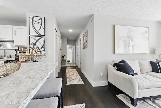 10605 Arnez Rd, Jacksonville, FL 32218 - hallway with a textured ceiling, dark wood-style flooring, a sink, and baseboards