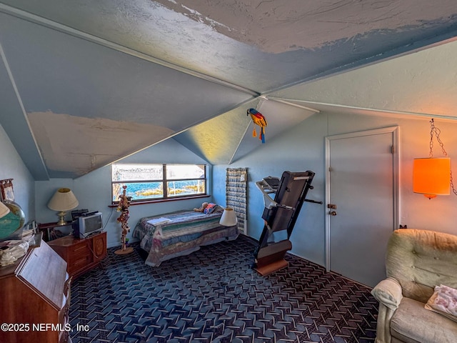 bedroom with dark colored carpet and lofted ceiling