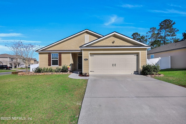 view of front of home featuring driveway, an attached garage, fence, and a front lawn