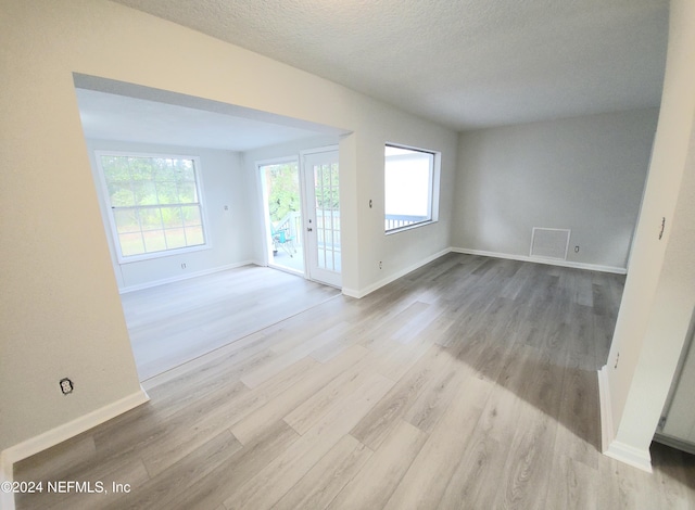 empty room featuring light wood-type flooring and a textured ceiling