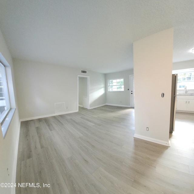 spare room with light wood-type flooring and sink