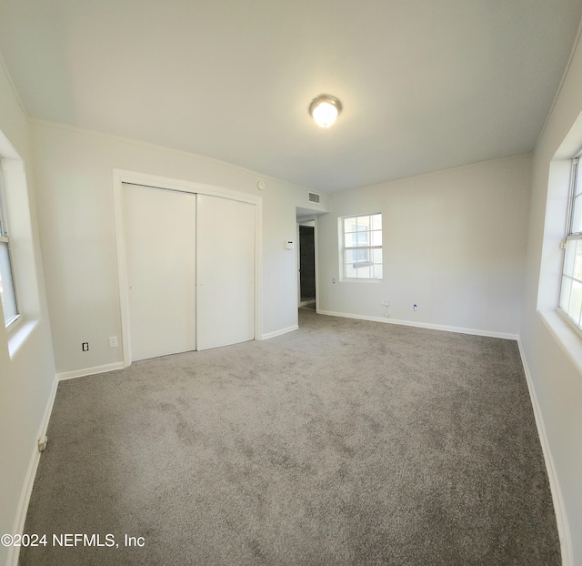 unfurnished bedroom featuring carpet and a closet