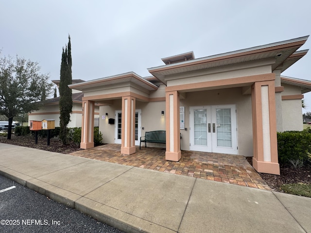 view of front of house with french doors and stucco siding