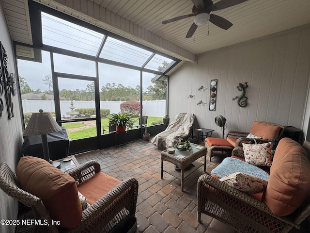 sunroom featuring a water view and a ceiling fan