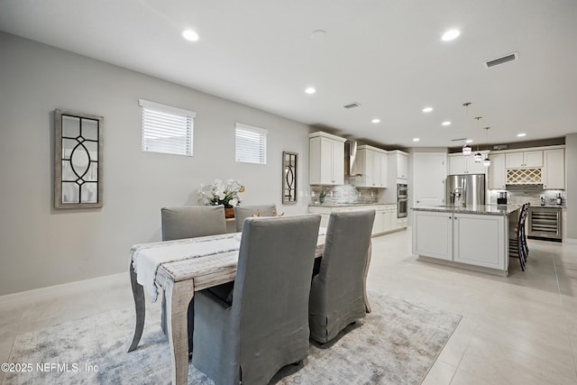 dining space featuring baseboards, wine cooler, visible vents, and recessed lighting