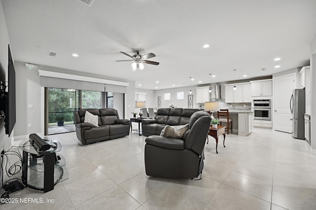 living area featuring a healthy amount of sunlight, light tile patterned flooring, visible vents, and recessed lighting