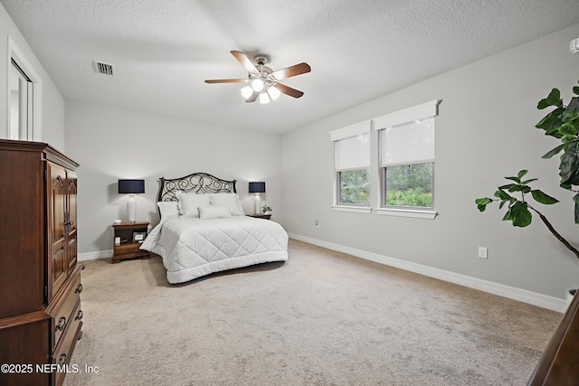 bedroom with light carpet, a textured ceiling, visible vents, and baseboards