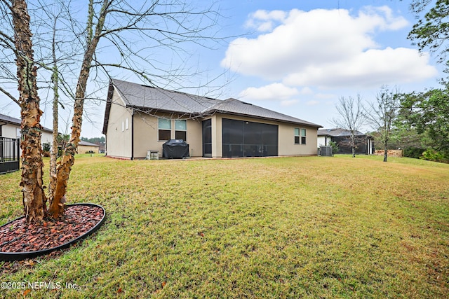 back of house with a sunroom and a lawn