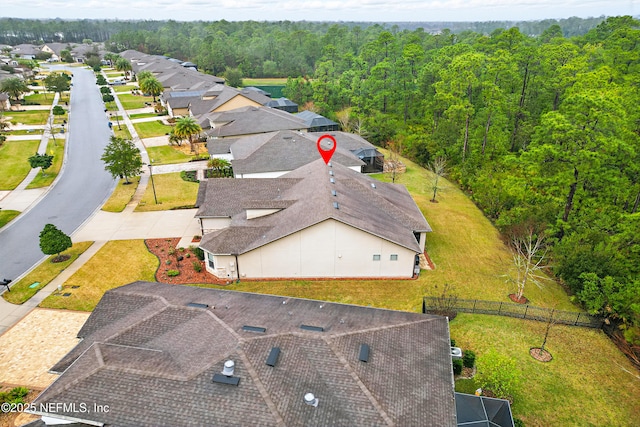 drone / aerial view with a residential view and a view of trees