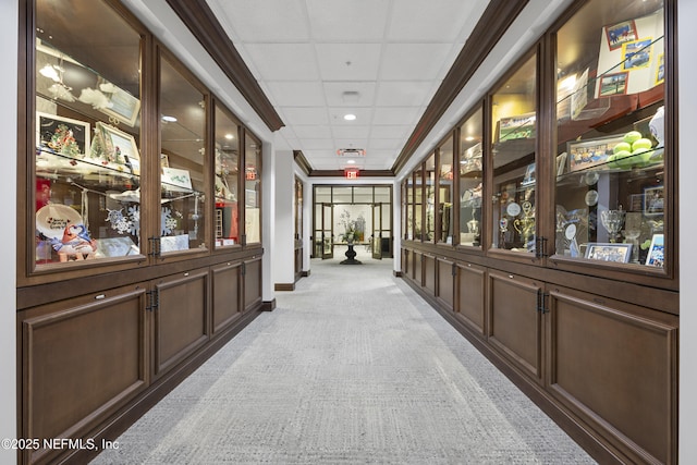 hallway featuring a paneled ceiling, carpet, visible vents, and baseboards