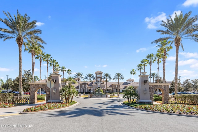 view of street featuring a residential view, a gated entry, and curbs