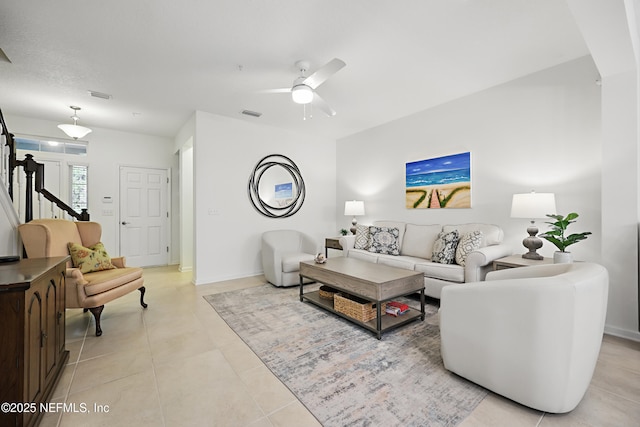 living room featuring stairs, visible vents, ceiling fan, and light tile patterned floors