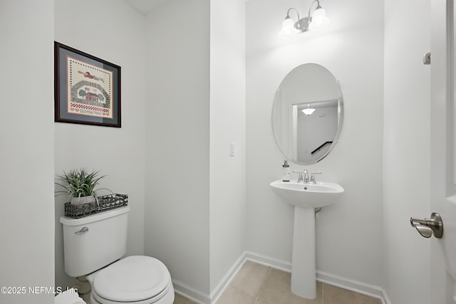 bathroom featuring baseboards, a sink, toilet, and tile patterned floors