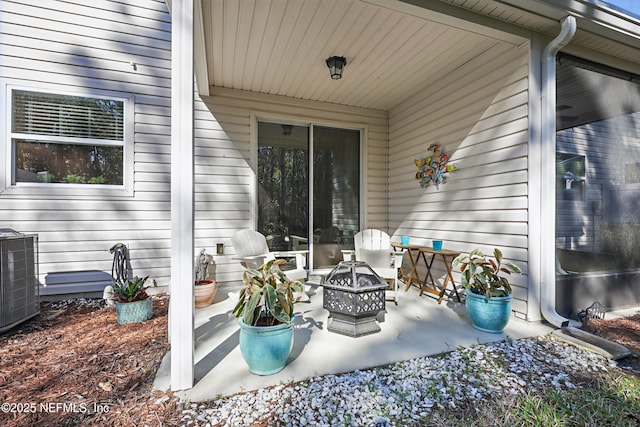 view of patio / terrace featuring an outdoor fire pit and cooling unit