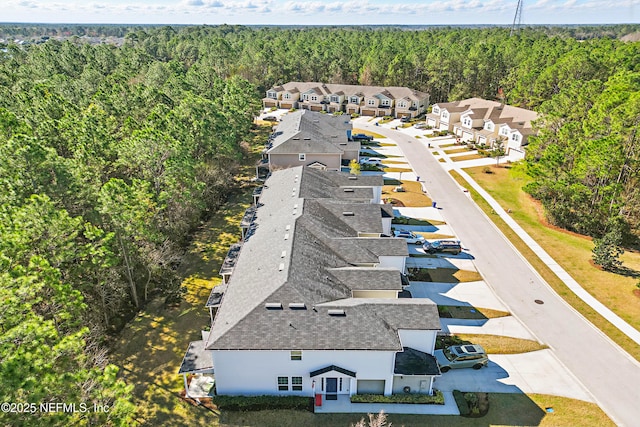 bird's eye view featuring a residential view and a wooded view