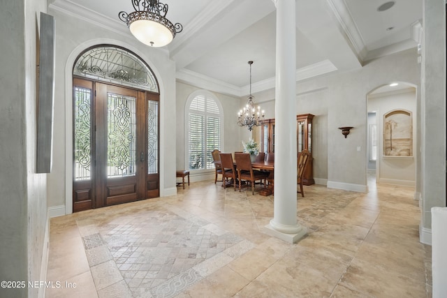 entryway featuring arched walkways, ornamental molding, a notable chandelier, and baseboards