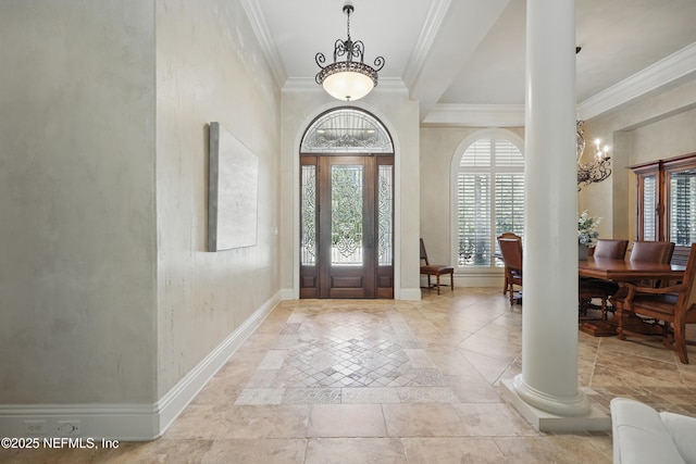 foyer featuring decorative columns, baseboards, and crown molding